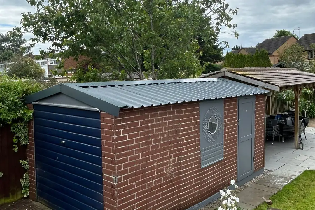 A brick garage with a new roof fitted by Excel Roofing & Asbestos