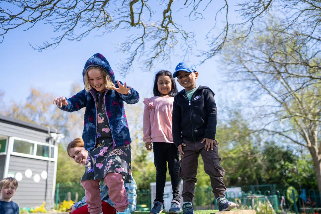 Three children playing outdoors at a FizzBug holiday club