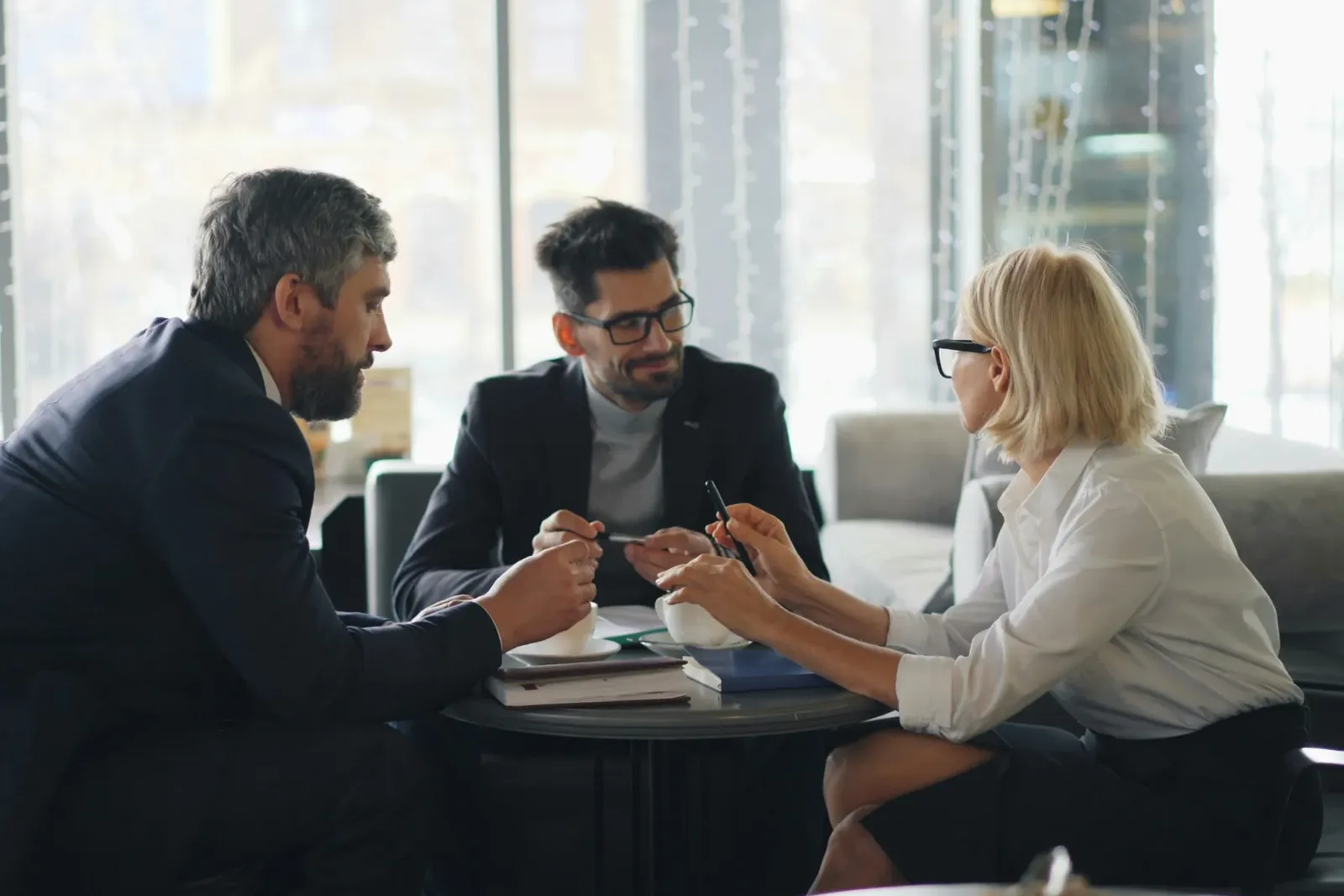 Three advisers talking around a small table