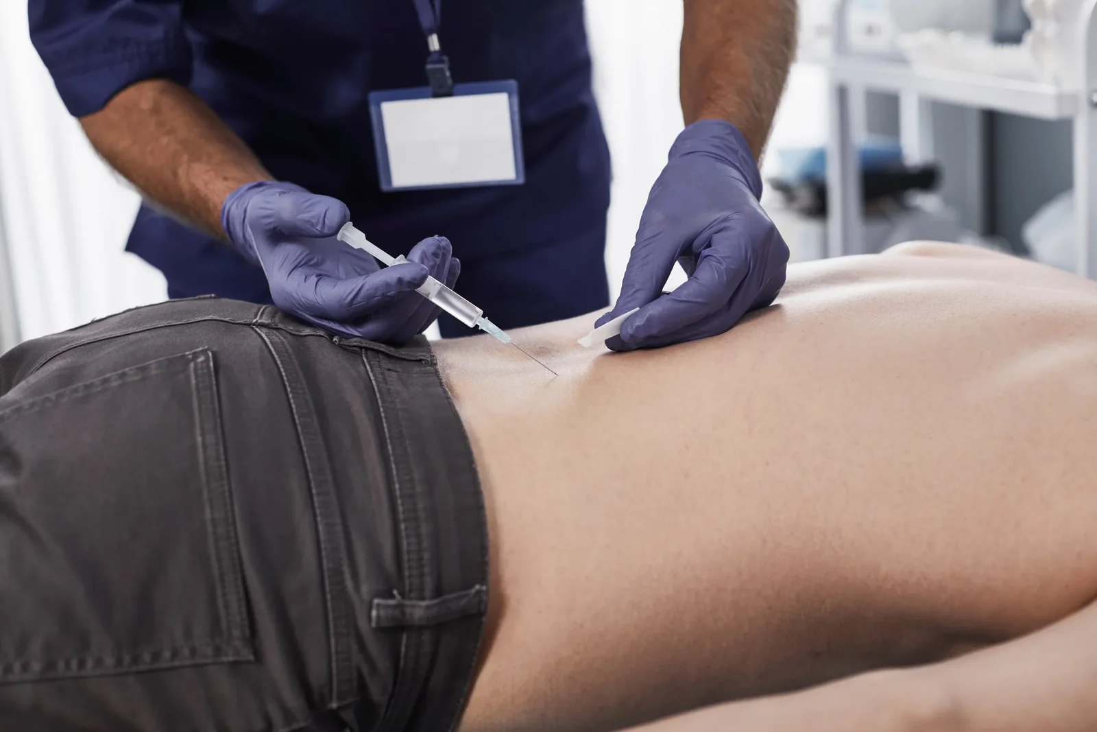 A clinician giving a prolozone injection to a patient&rsquo;s lower back