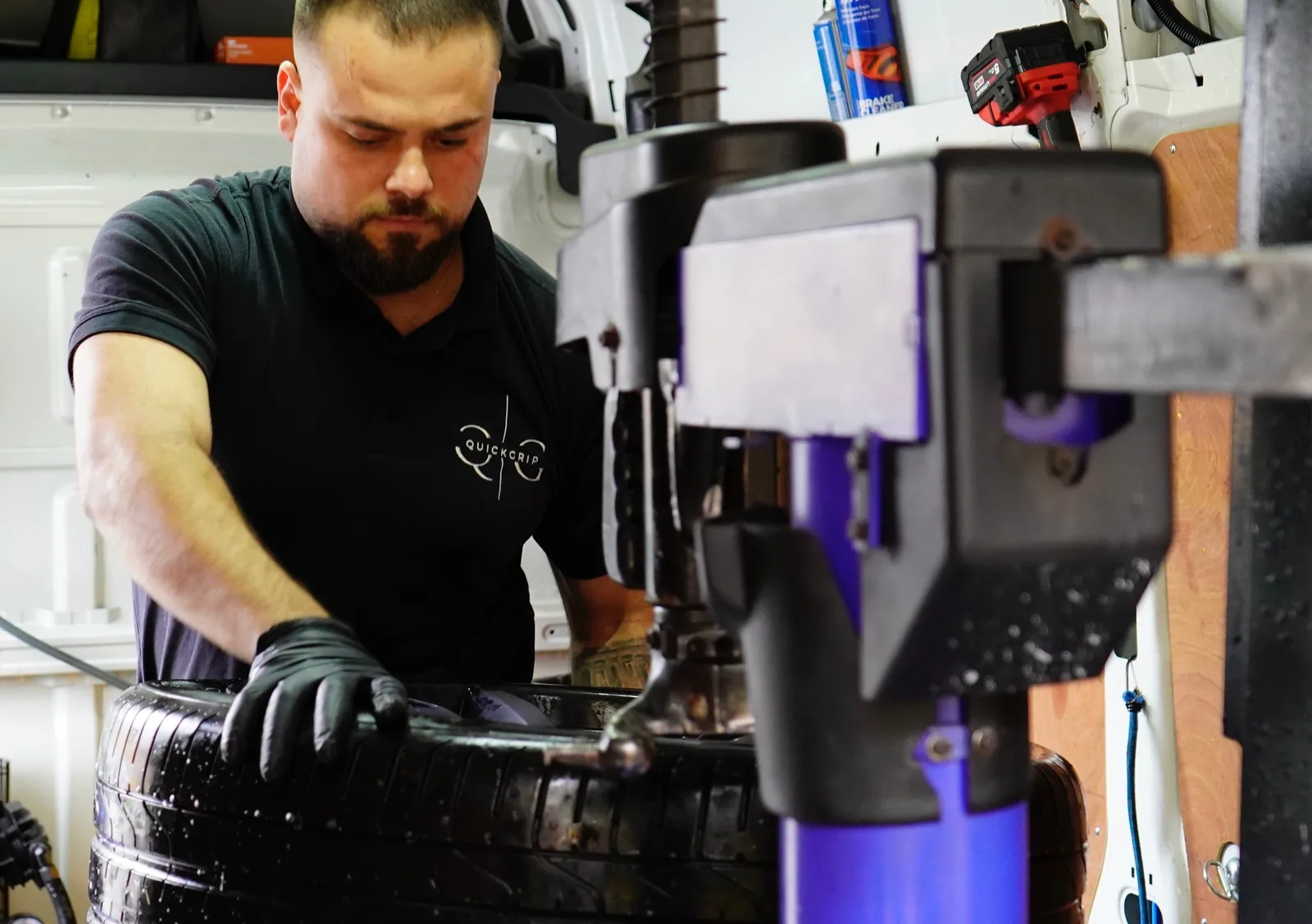 A QuickGrip fitter using the tyre machine in the back of the van